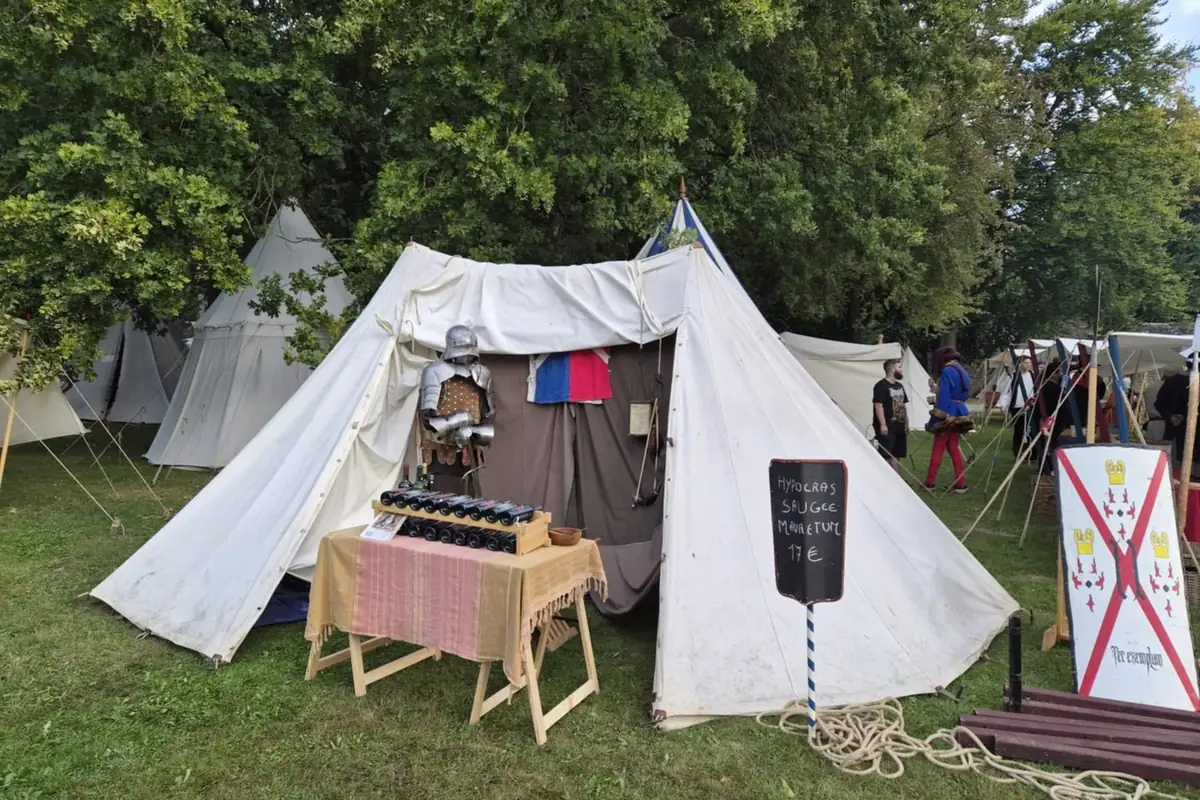 Le stand de L'Alchymiste devant une tente de campement médiéval, lors d'une fête de reconstitution